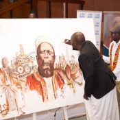 Owek. Mugenyi Fred Rucunya, the Chief Prince of Bunyoro-Kitara Kingdom signing 100 Years of Kabalega commemoration  artwork by Mr. Tibirushya.