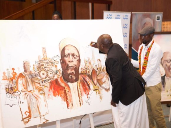 Owek. Mugenyi Fred Rucunya, the Chief Prince of Bunyoro-Kitara Kingdom signing 100 Years of Kabalega commemoration  artwork by Mr. Tibirushya.